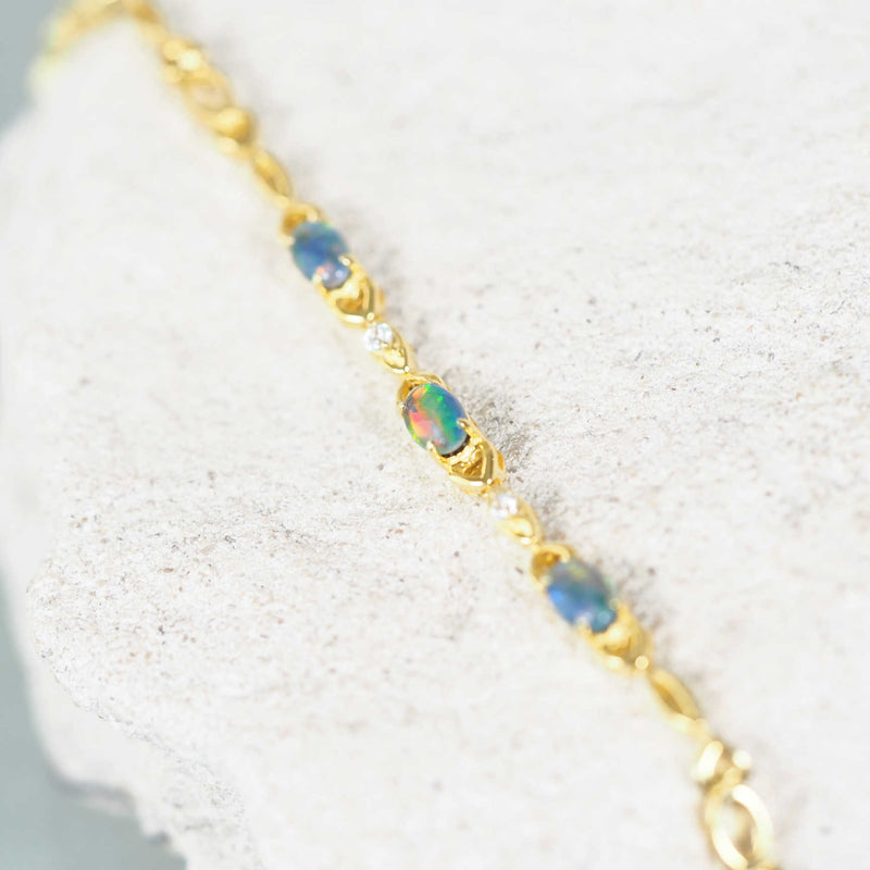 Gold-plated silver triplet opal bracelet featuring a vibrant multi-color opal centerpiece, showcasing hues of blue, green, and red, set in a sleek and elegant design perfect for adding a touch of sophistication to any outfit.