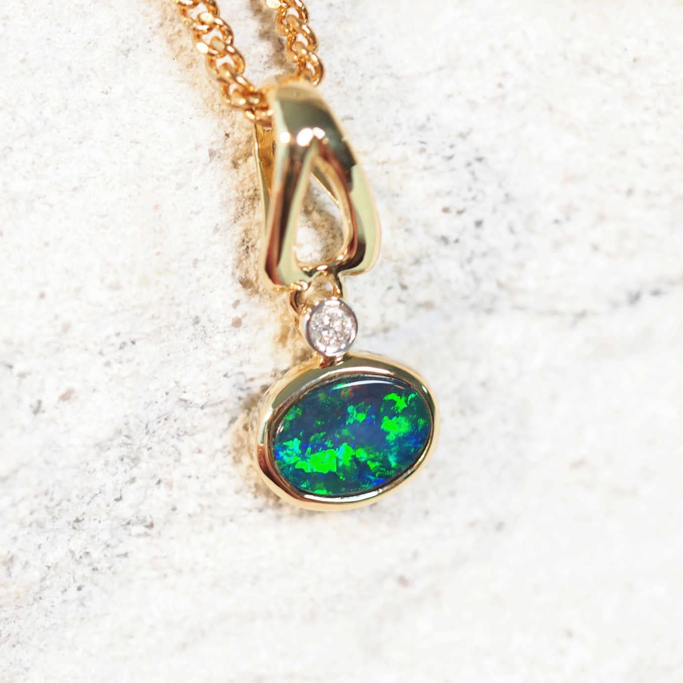 blue and green opal and diamond pendant set in 14ct yellow gold