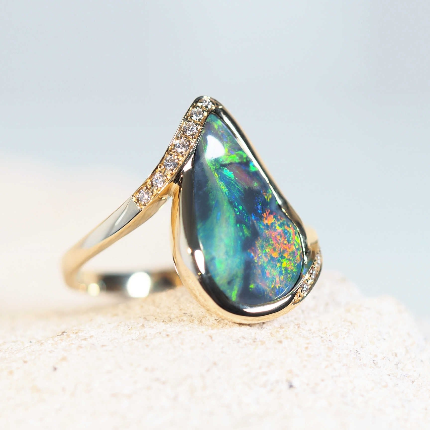 gold opal ring. featuring a black opal with an undulating surface