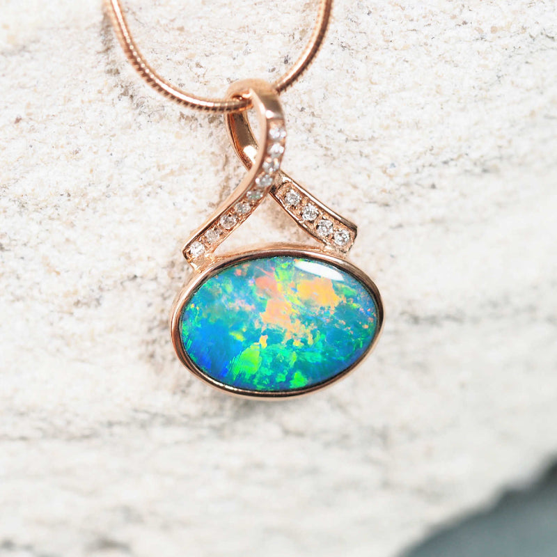 Elegant opal pendant in blue-green hues with multi-colour highlights and diamond accents.