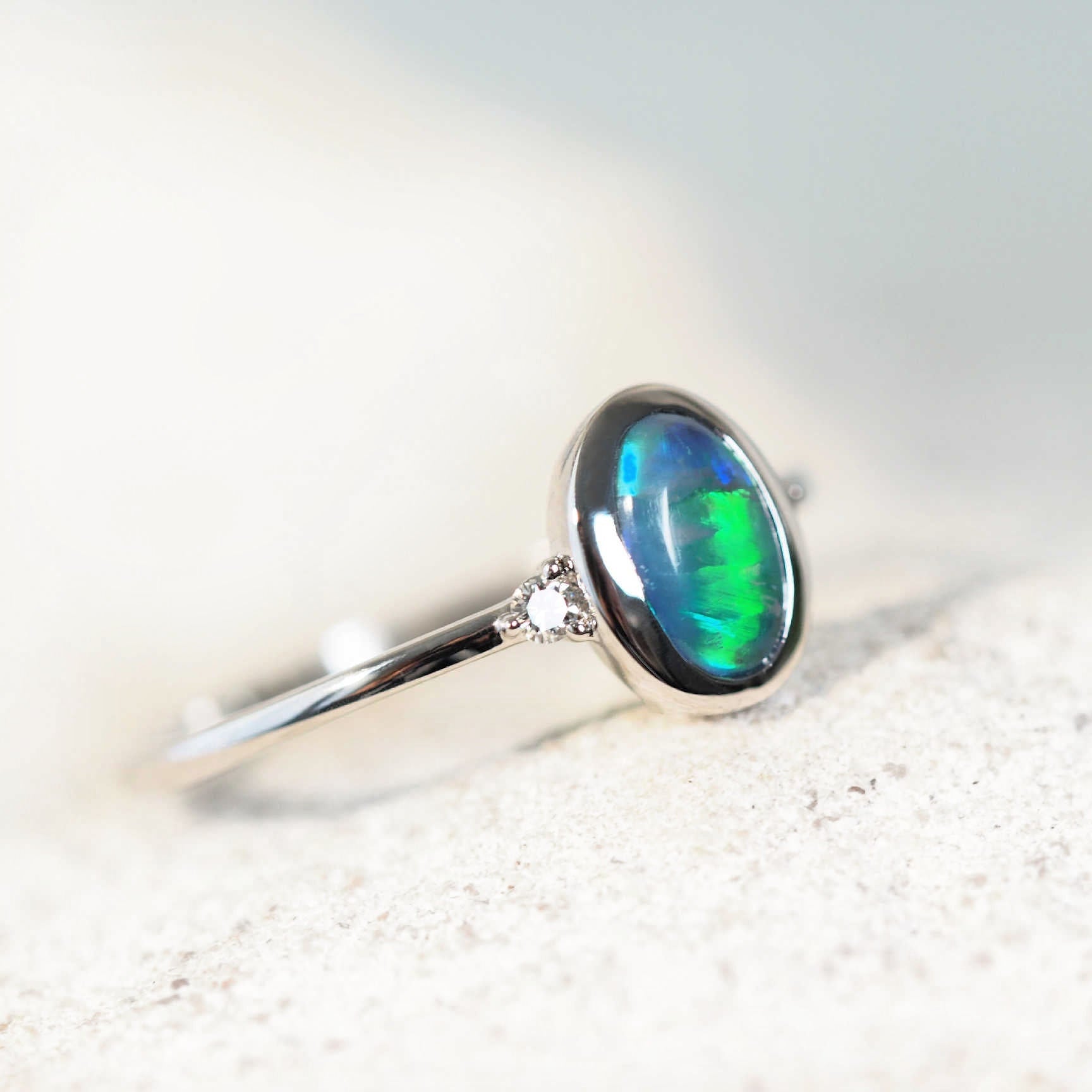 Elegant 14ct white gold Anneisha opal ring showcasing a green oval Lightning Ridge black opal with two dazzling white diamond accents.