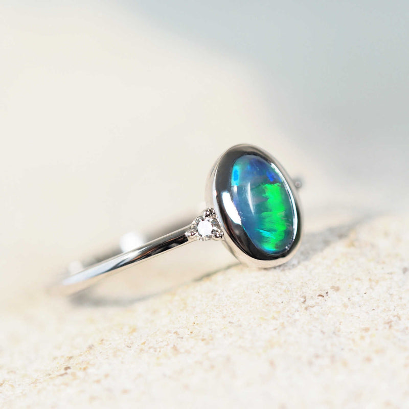 Elegant 14ct white gold Anneisha opal ring showcasing a green oval Lightning Ridge black opal with two dazzling white diamond accents.