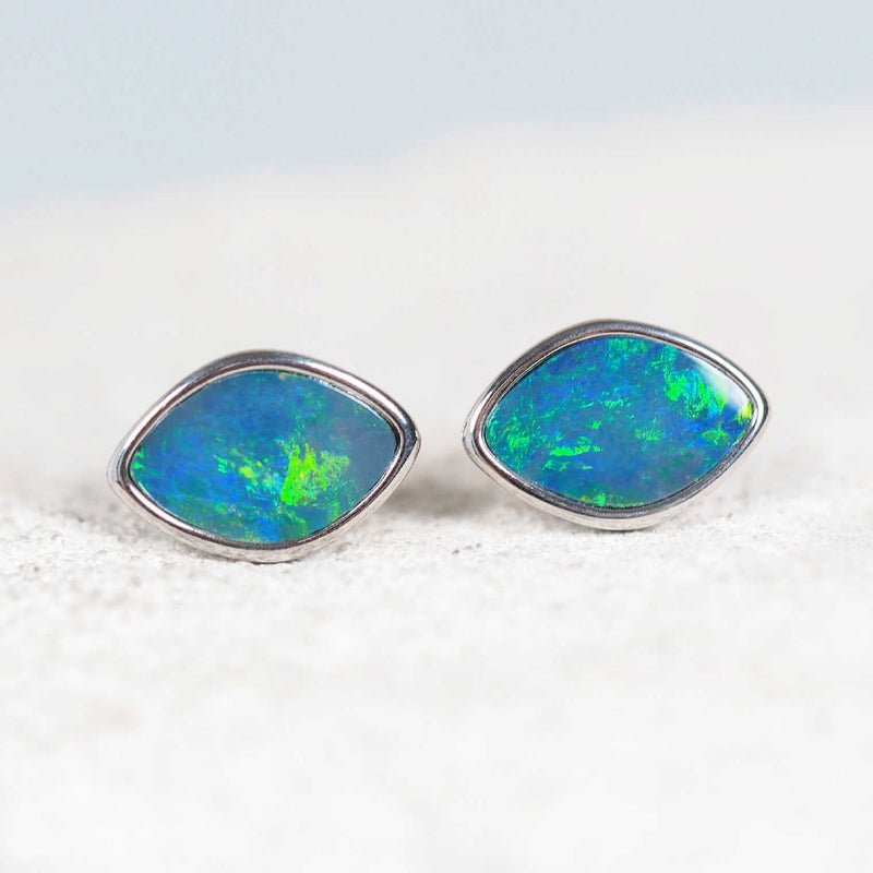 close up of opal earrings set in sterling silver with a diamond shape