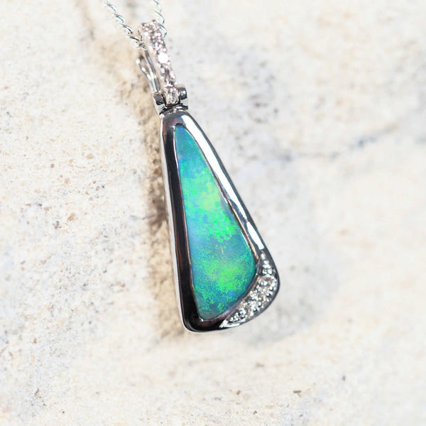 black opal pendant featuring a green gemstone set into white gold