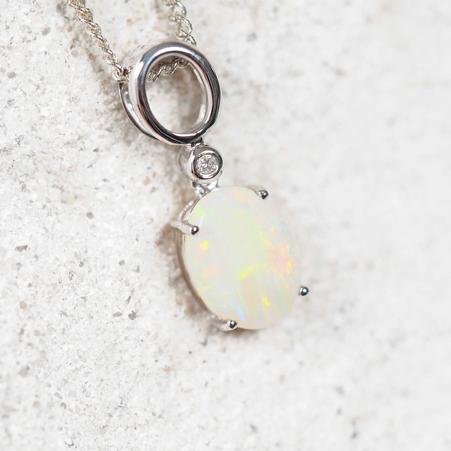 colourful white opal pendant set in white gold with a diamond