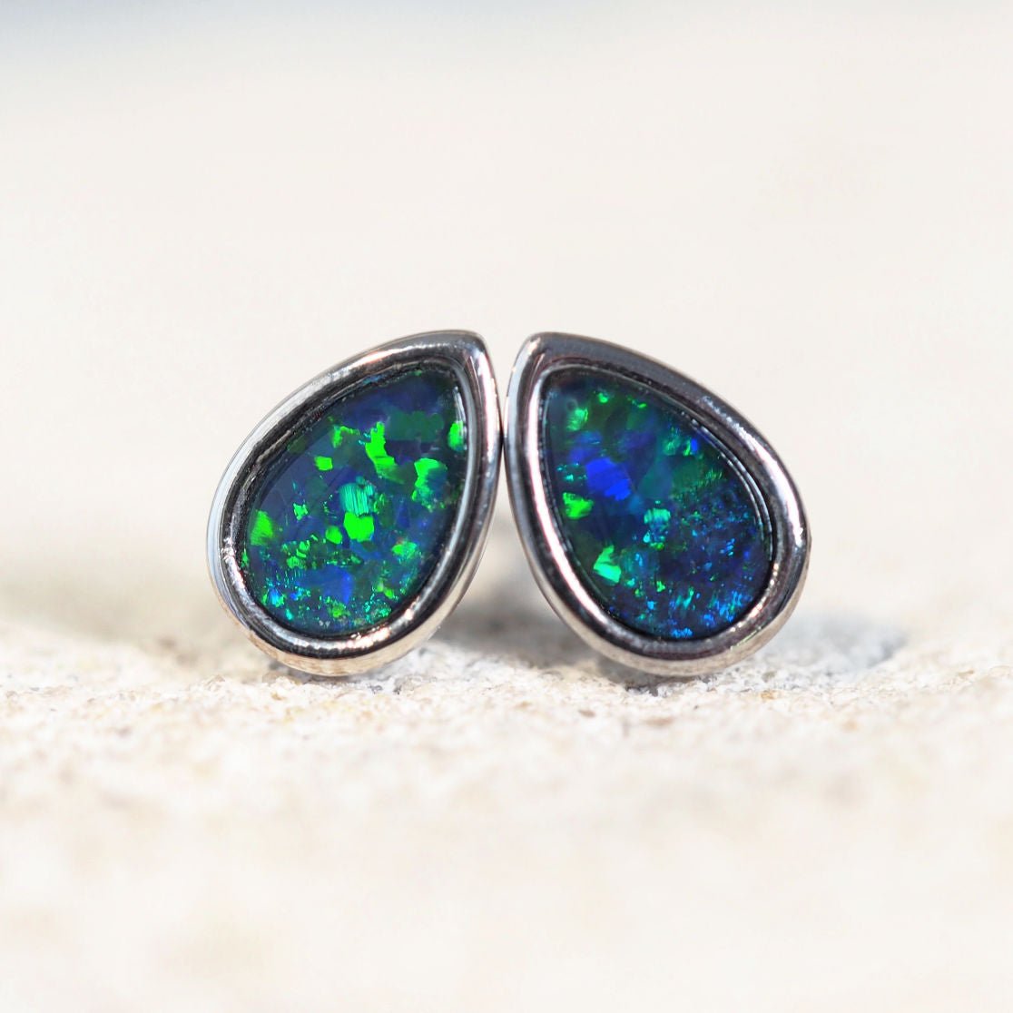 stud opal earrings set with blue and green opals