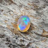 Ethereal rolling flash patterned oval Lightning Ridge solid crystal opal with blue and green highlights, ideal for a ring or necklace pendant setting.