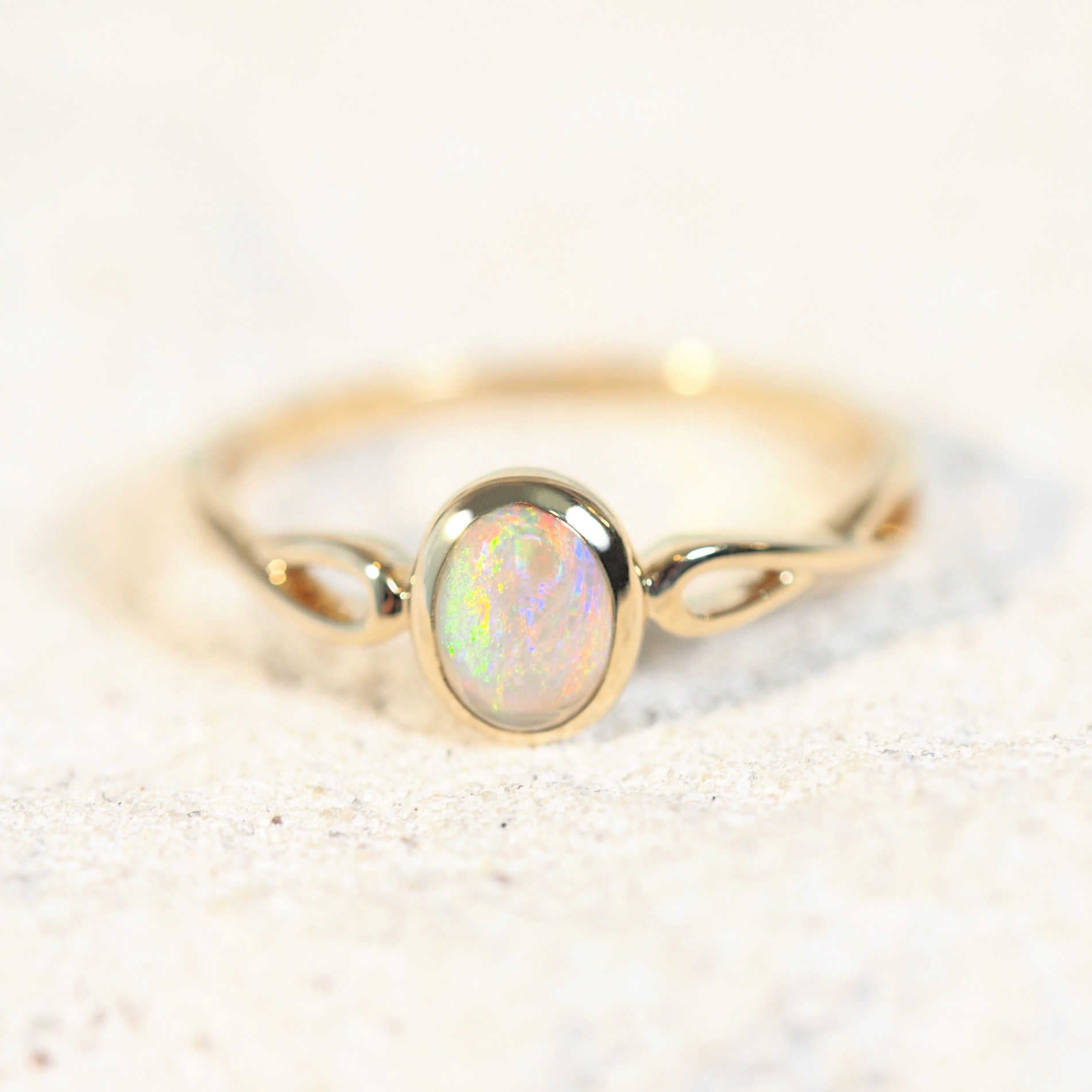 colourful opal ring set in yelow gold with a twisted band