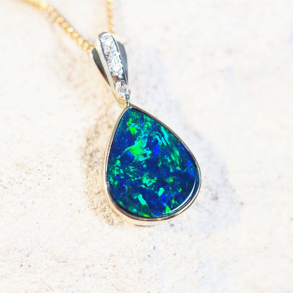 gold doublet opal pendant with a blue and green opal and four diamonds