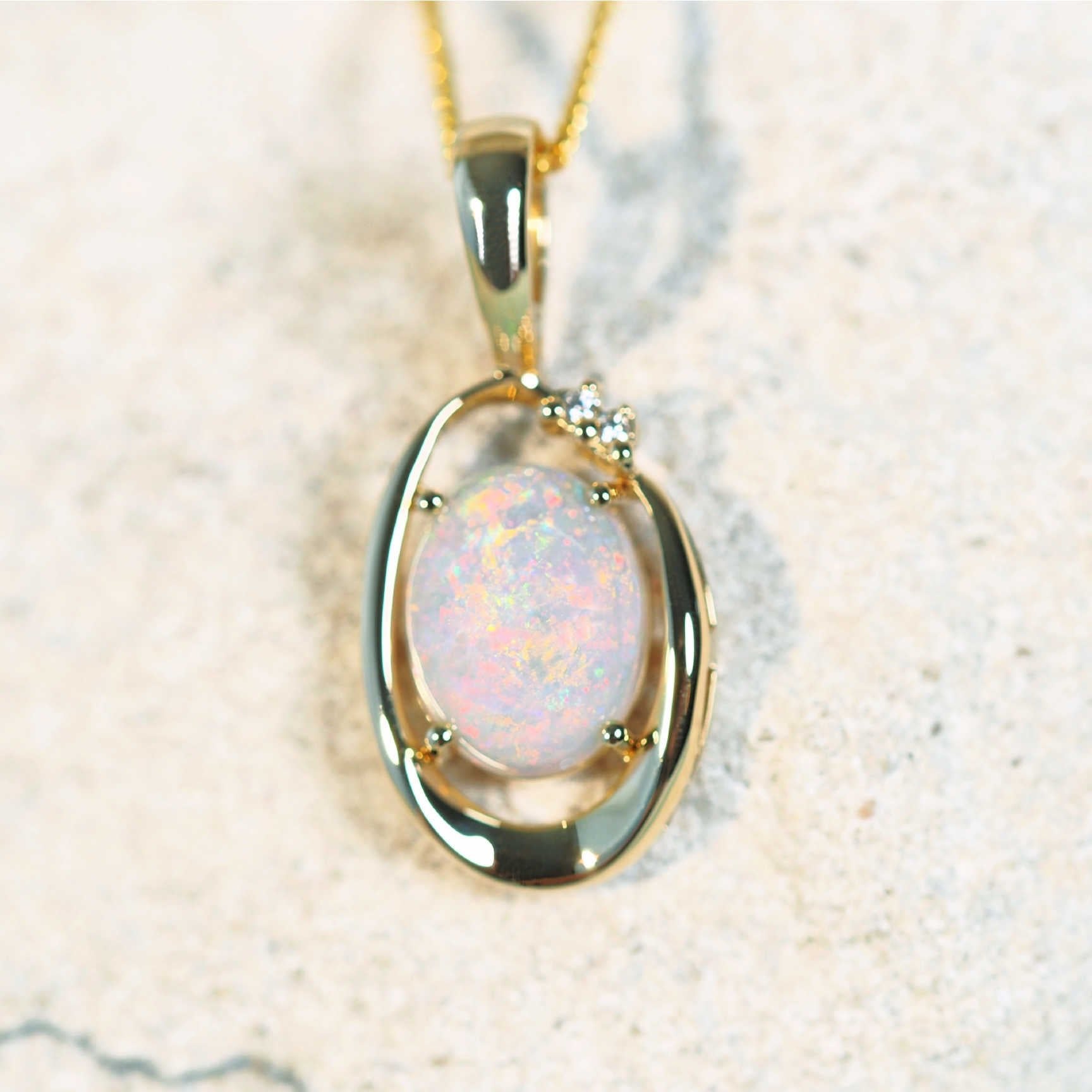 colourful oval gold opal pendant with two diamonds