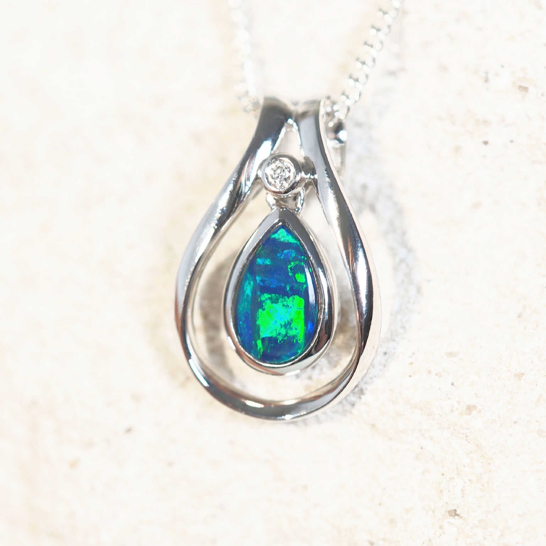 Lainey opal pendant in 14ct white gold featuring a vivid blue-and-green teardrop-shaped Australian doublet opal and a sparkling white diamond.