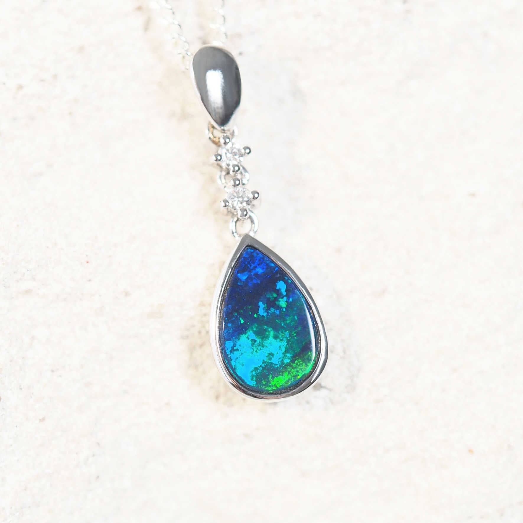 opal pendant set with a blue and green doublet opal set into 14ct white gold