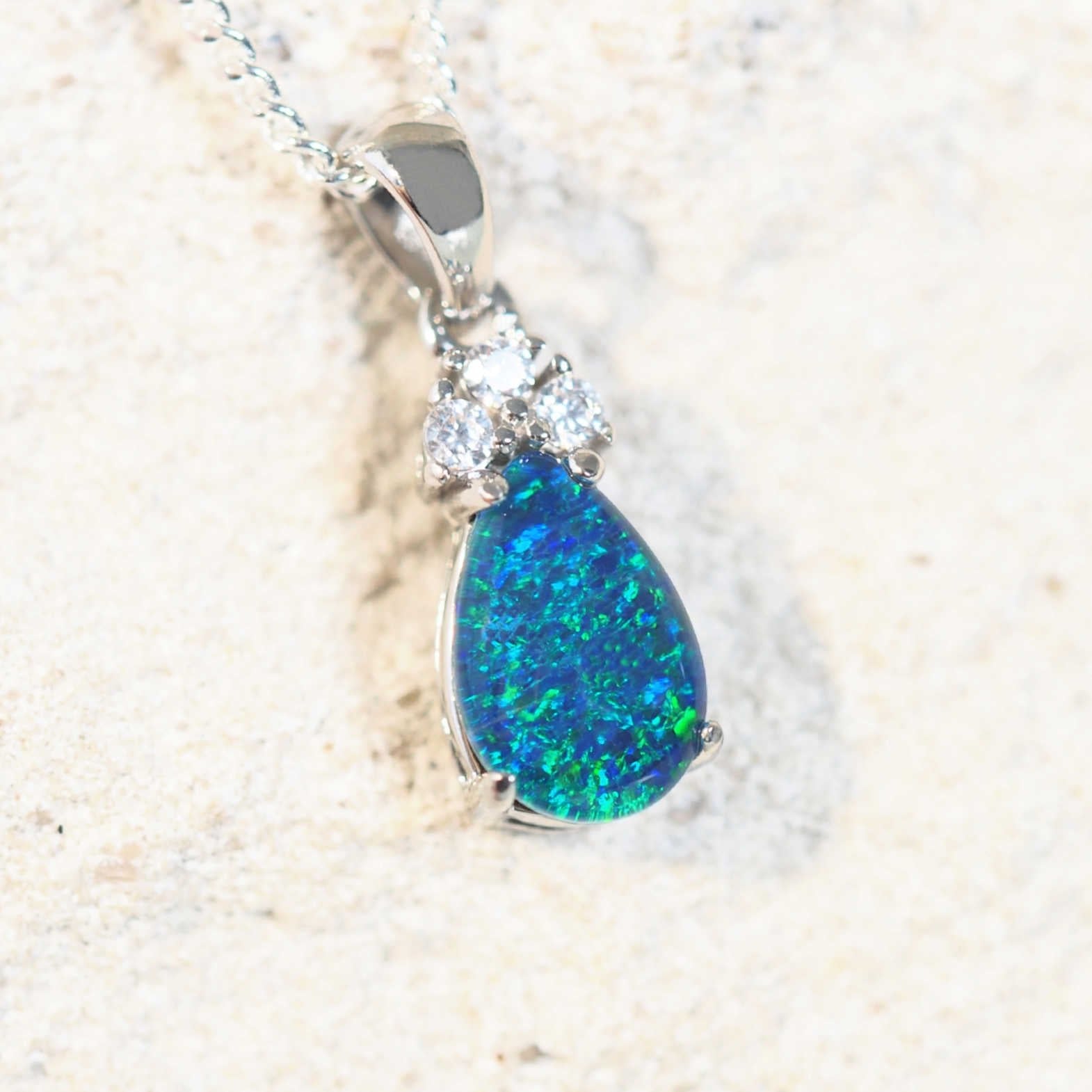 Close-up of the 'Lola Blue' opal pendant featuring vibrant blue and green hues with cubic zirconias.