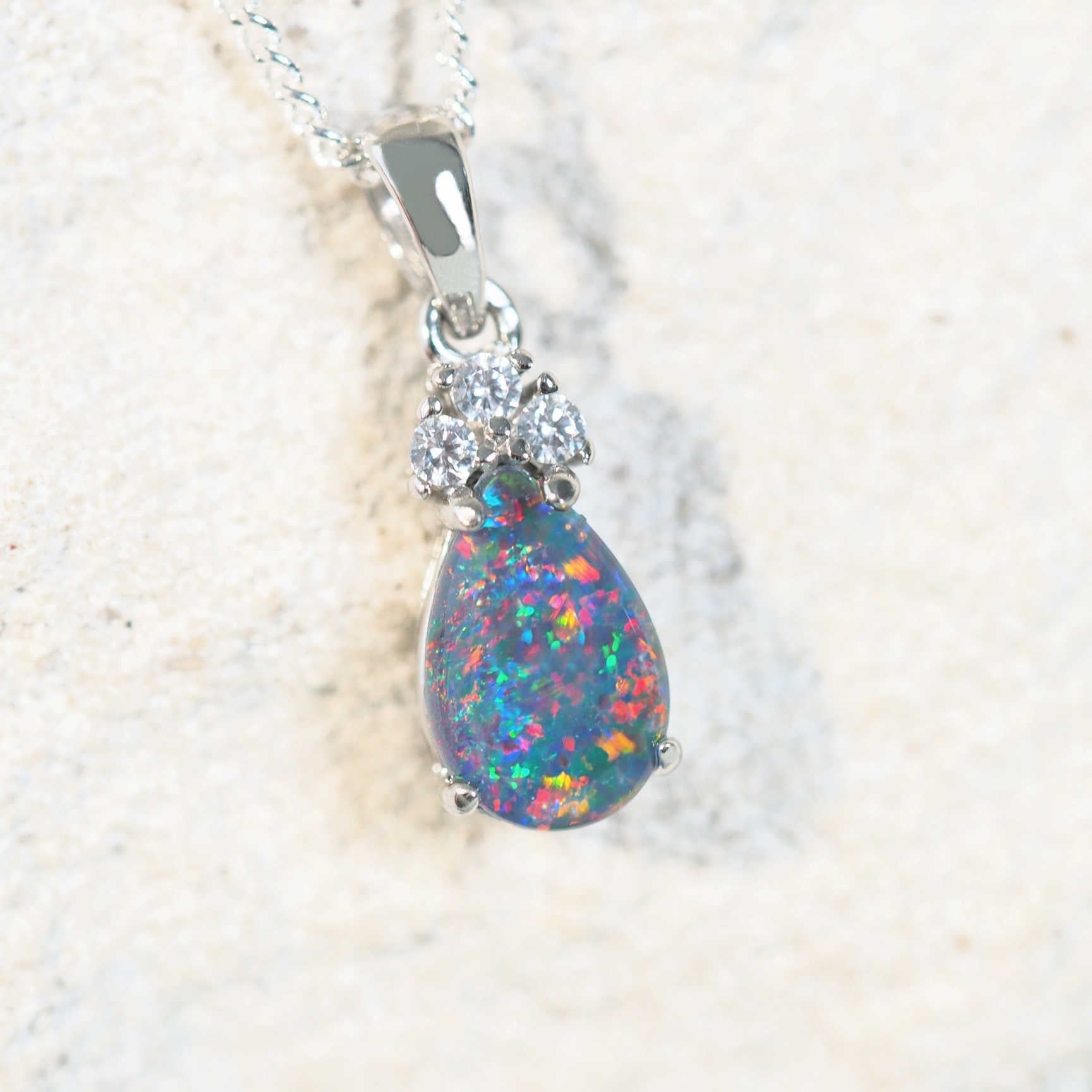 Sterling silver opal pendant featuring an oval-shaped Australian triplet opal and cubic zirconias.