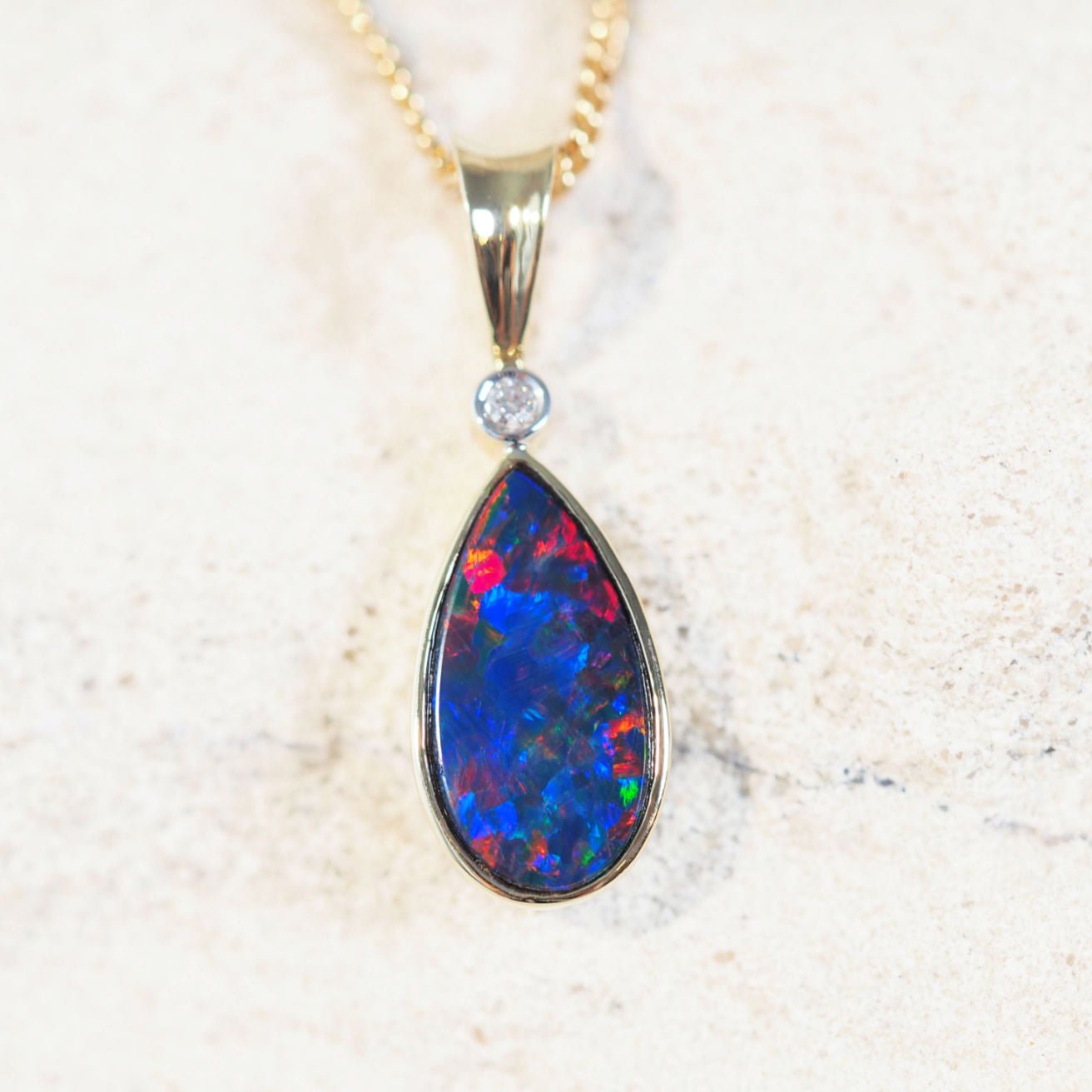 colourful teardrop shape gold opal pendant with one diamond