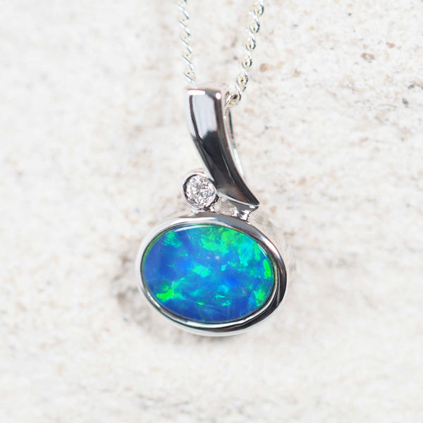 Marina opal pendant in 14ct white gold featuring a blue-and-green Australian doublet opal, oval-shaped and bezel set with a sparkling white diamond accent.