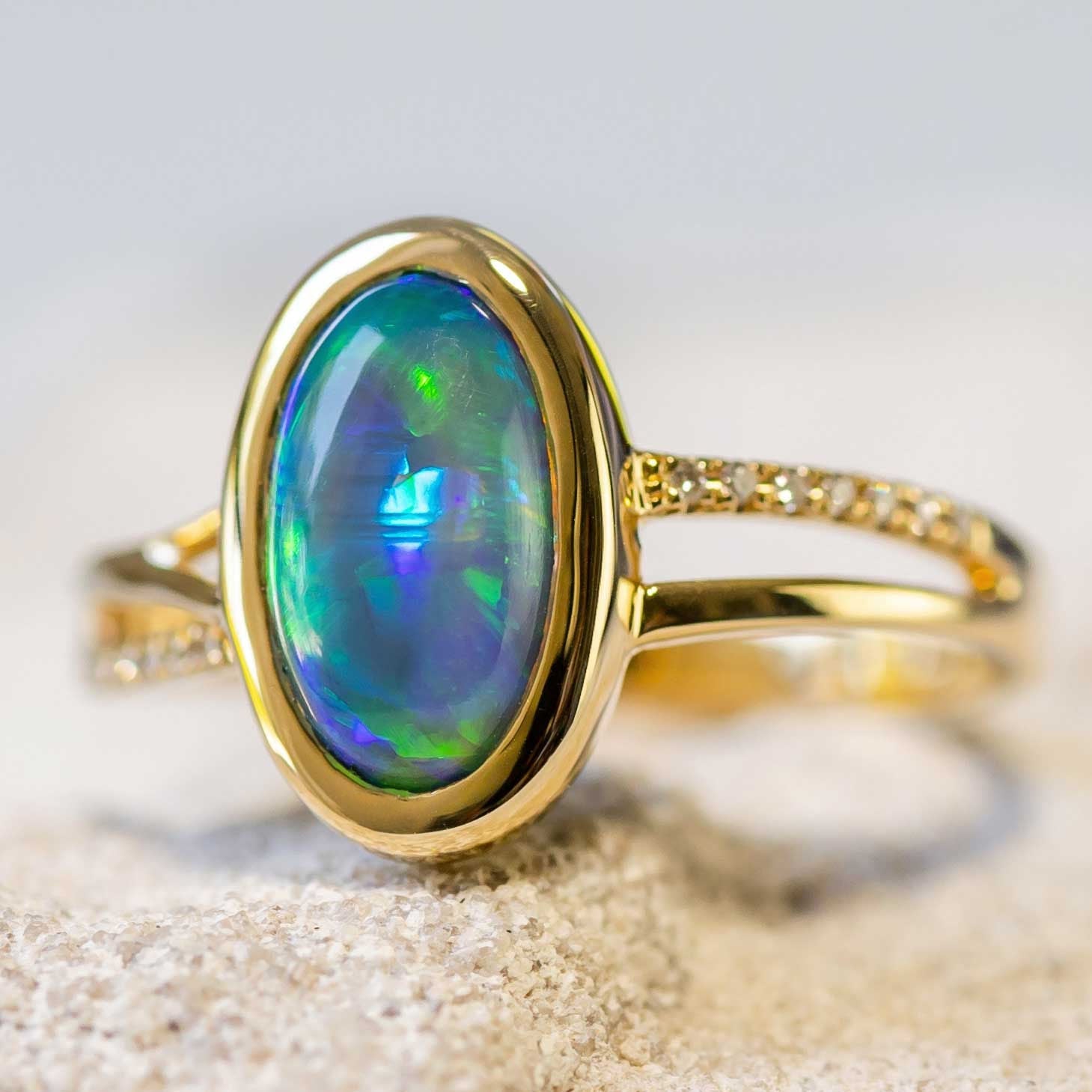 Elegant handcrafted 18ct yellow gold opal ring with a vibrant blue, green, and orange Lightning Ridge crystal opal and sparkling diamonds.