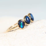 black opal ring featuring three blue coloured lightning ridge opals set into a gold band