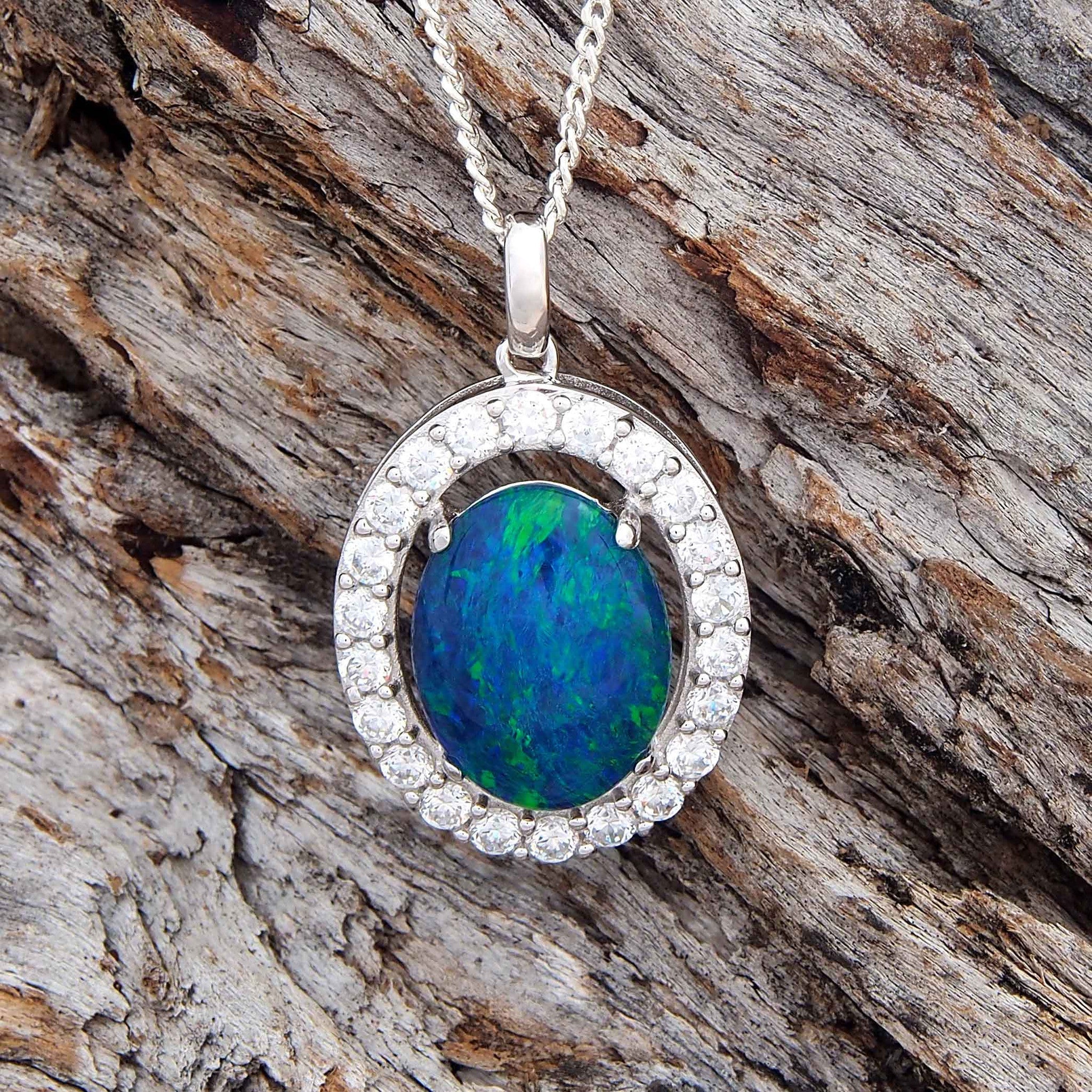 Stunning sterling silver necklace pendant claw set with a blue green oval triplet opal ringed with twenty two claw set cubic zirconias.