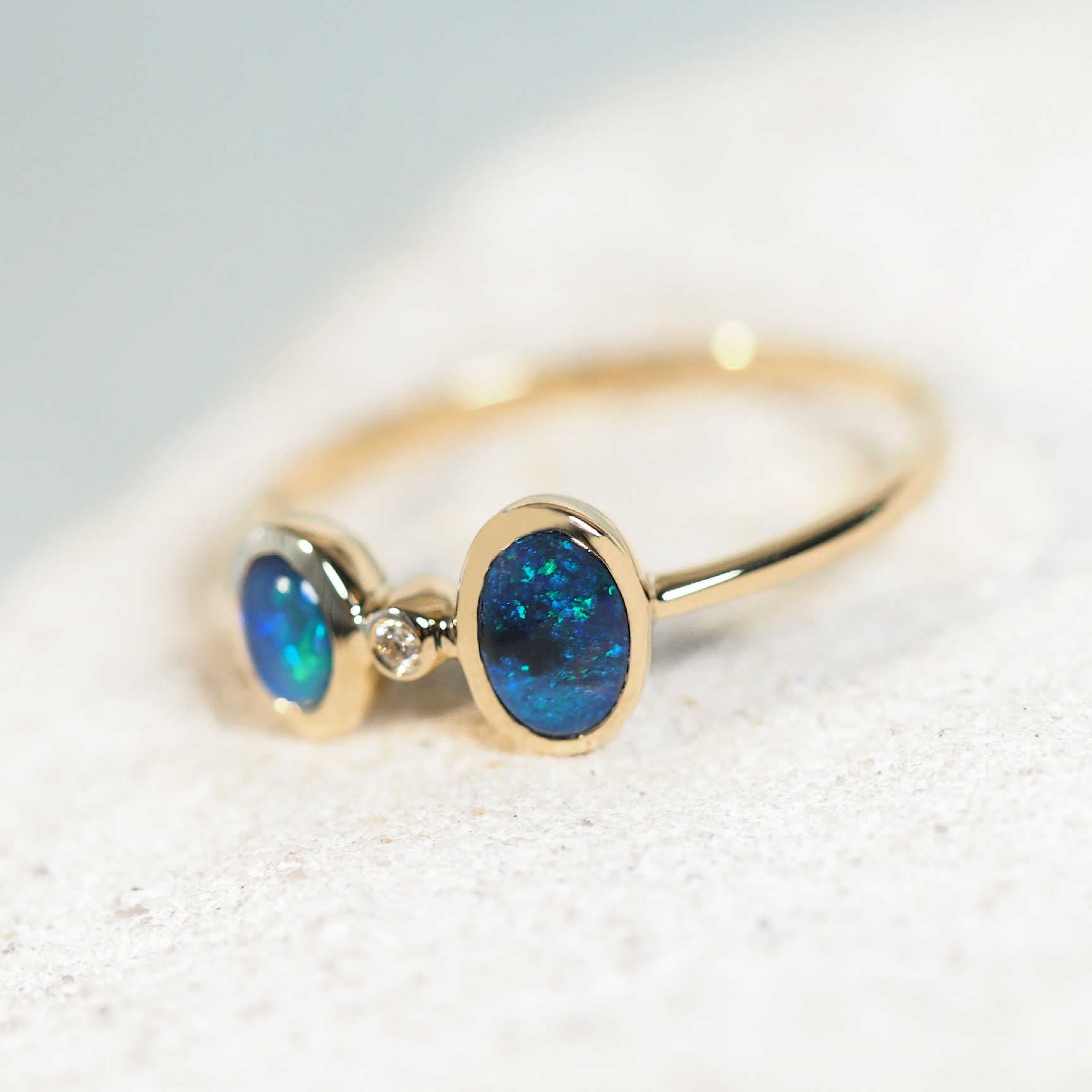 ring with two blue and green lightning ridge black opals set in gold