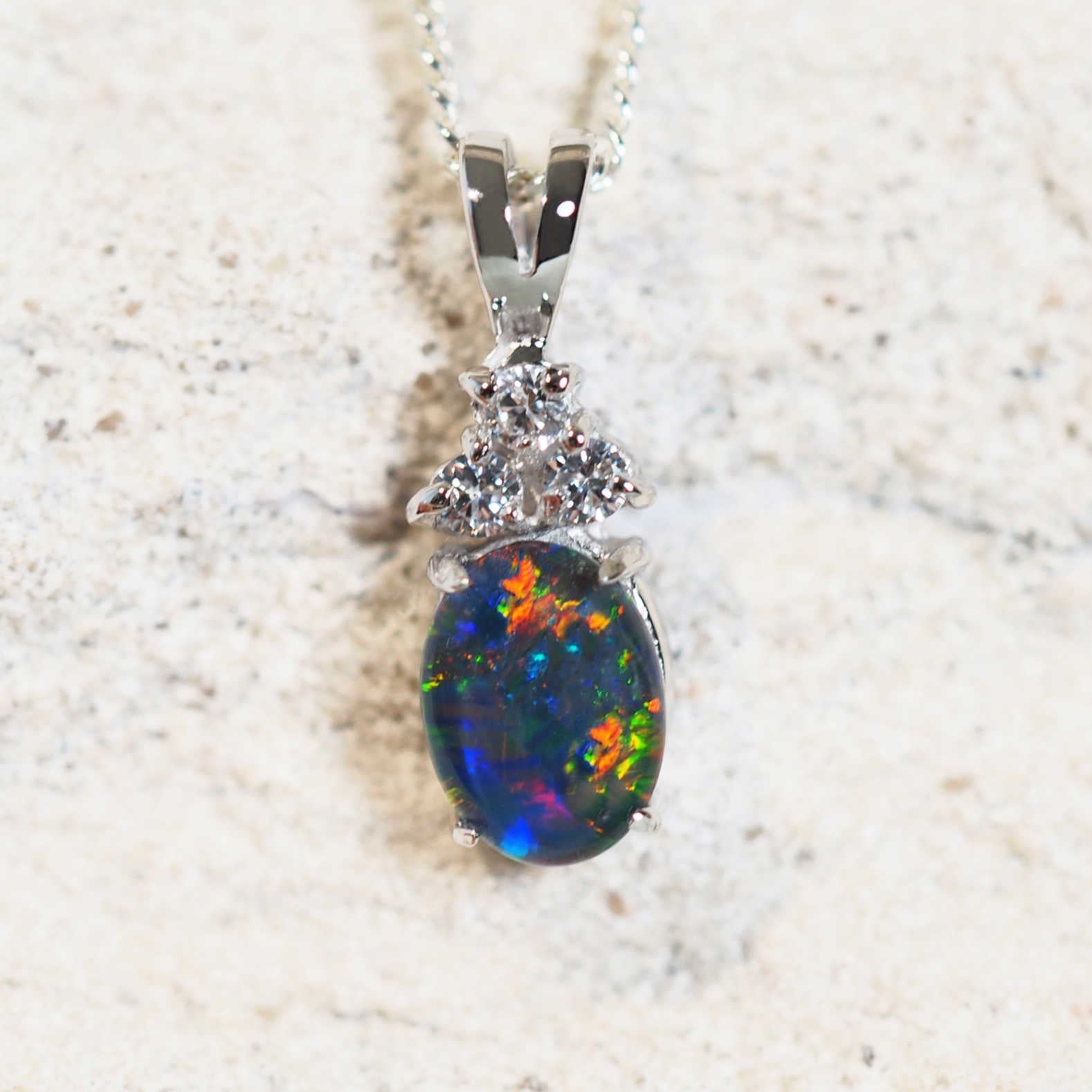 colourful opal set in sterling silver with three diamantes set into a pendant