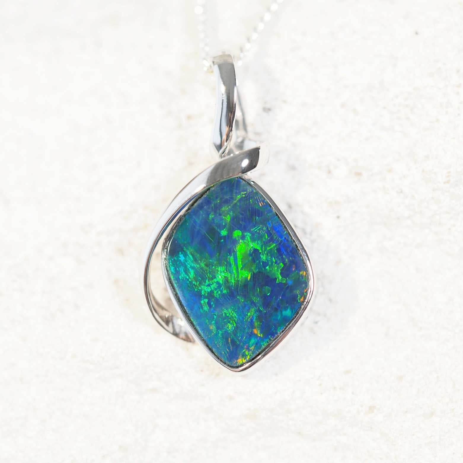 Varena opal pendant in 14ct white gold featuring a bright blue-and-green diamond-shaped Australian doublet opal, elegantly bezel set for a modern design.