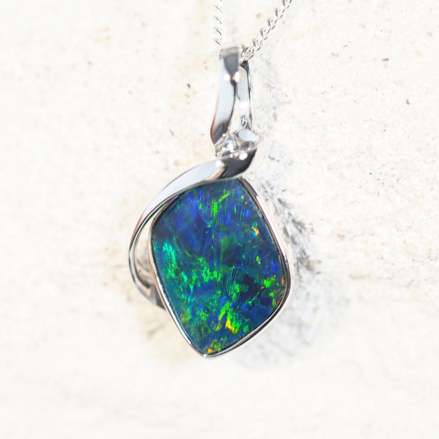 Elegant Varena opal necklace with a vibrant diamond-shaped Australian doublet opal, handcrafted in 14ct white gold with a secure bezel setting.