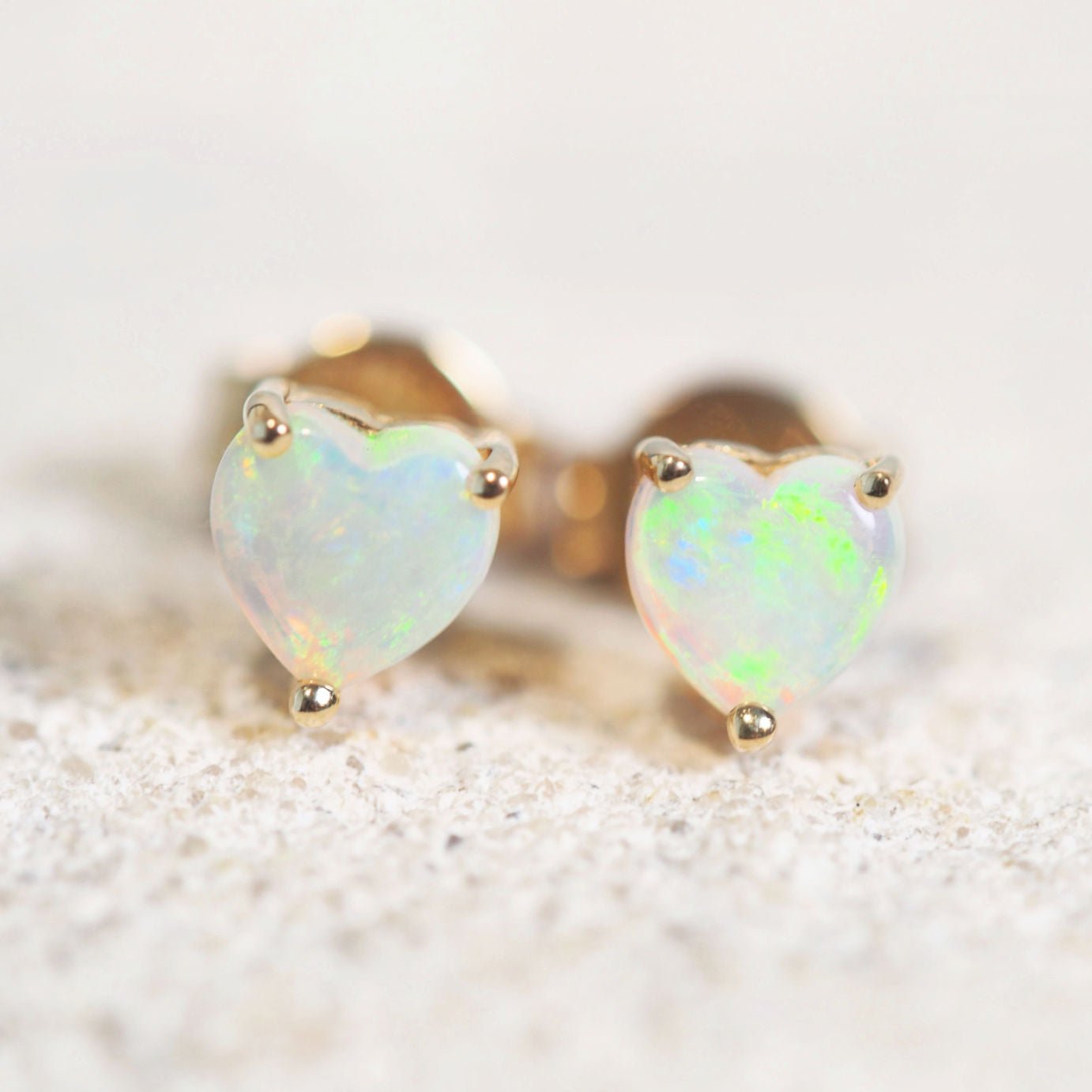 heart shaped crystal opal gold earrings with a green tone