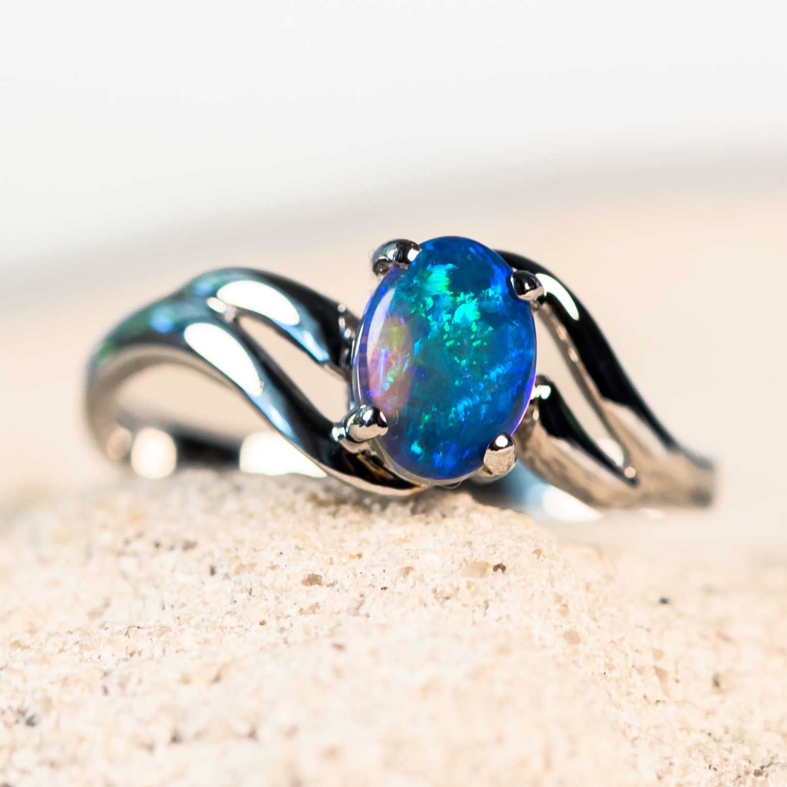 blue and green crystal opal set into a white gold ring